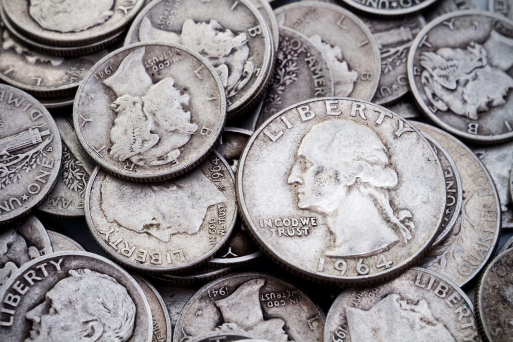 A pile of old circulated worn collectible silver dimes and quarters. Could be used for silver bullion themes as well as coin collectible themes.